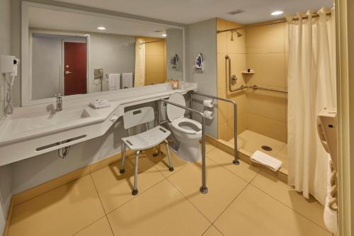 a bathroom with a toilet and a sink and a mirror at City Express by Marriott Reynosa in Reynosa