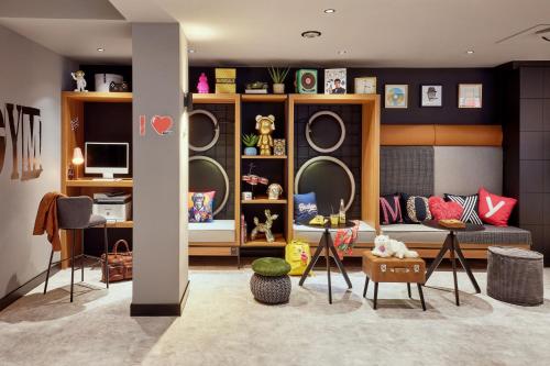 a living room with a couch and chairs and mirrors at Moxy Bochum in Bochum