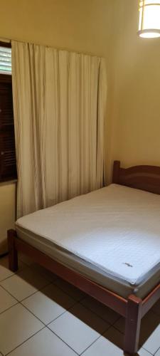 a bed sitting in a room with at Sítio Guaramiranga para 10 pessoas com fácil acesso in Guaramiranga
