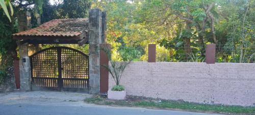 a fence with a gate and a potted plant at Sítio Guaramiranga para 10 pessoas com fácil acesso in Guaramiranga