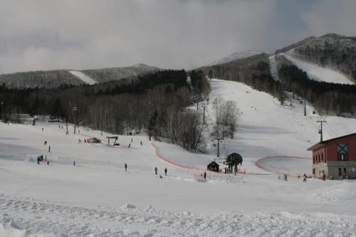 a group of people skiing down a snow covered slope at 静かな田舎の一軒家 ご家族友達観光大型スキー場近郊 in Mikage