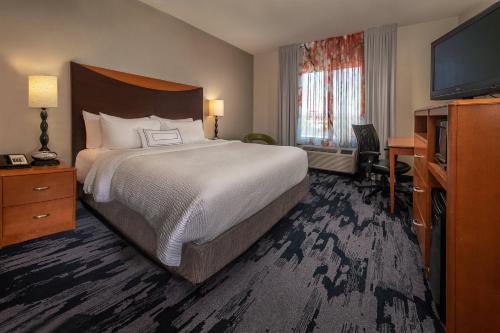 Fairfield Inn and Suites by Marriott Harrisonburg في هاريسونبيرغ: غرفة فندقية بسرير وتلفزيون بشاشة مسطحة