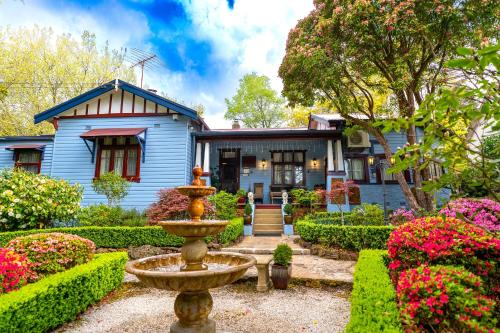 een huis met een tuin met een fontein ervoor bij KUBBA ROONGA GUESTHOUSE - Boutique Luxury Peaceful Stay & Gardens - Bed & Breakfast in Blackheath