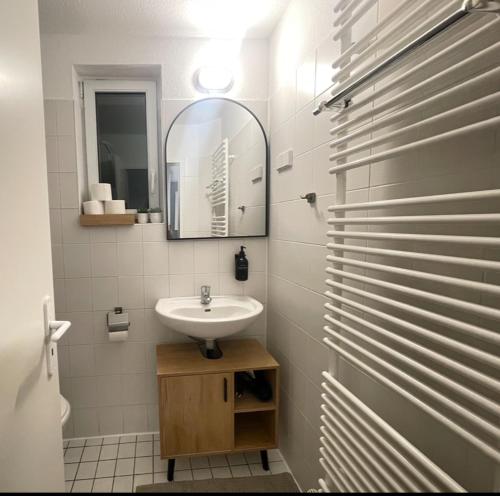 a white bathroom with a sink and a mirror at Charmantes TinyHouse im Zentrum - MalliBase Apartments in Hannover