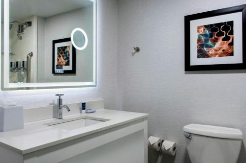 uma casa de banho branca com um lavatório e um espelho em Four Points Philadelphia Northeast em Filadélfia
