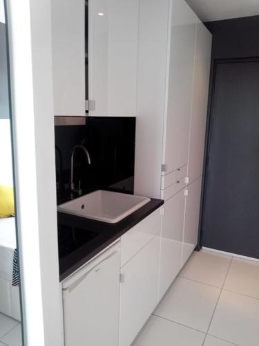 une cuisine avec des armoires blanches et un évier dans l'établissement Naturiste Cap d'Agde Port Nature 650, au Cap d'Agde