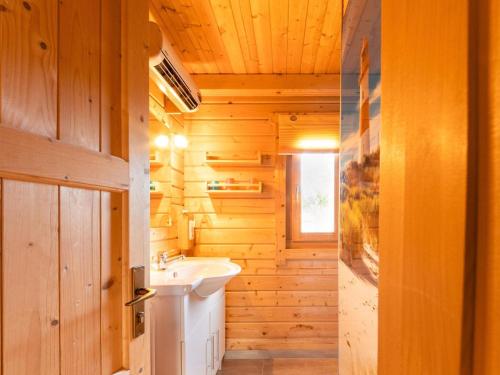 uma casa de banho com paredes de madeira, um lavatório e uma janela em Scandinavian wooden house in Plate em Plate