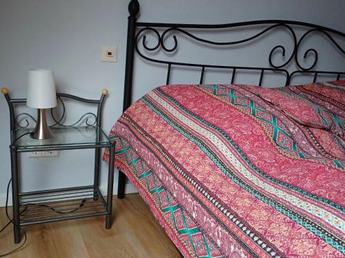 1 cama con edredón rojo y mesa auxiliar en Comfortable accommodation in middle of a winery 