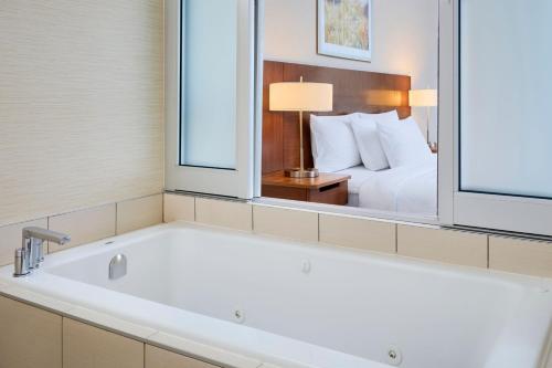 a bath tub in a hotel room with a bed at Fairfield Inn & Suites by Marriott Ottawa Kanata in Ottawa