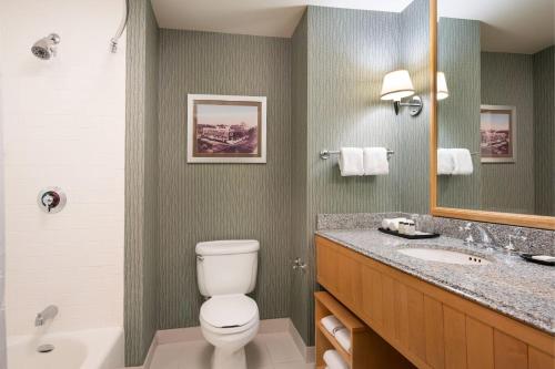 a bathroom with a toilet and a sink and a mirror at Sheraton Grand Sacramento in Sacramento