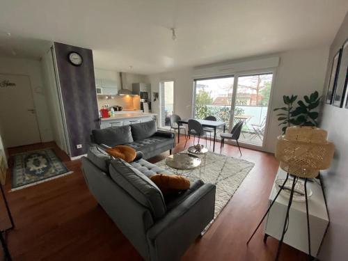 un salon avec un canapé et une table dans l'établissement Appartement 80m2, terrasse sud, metro 7 direction Louvre à 8minutes, parking sous-sol, proche Paris-Bercy, à Ivry-sur-Seine