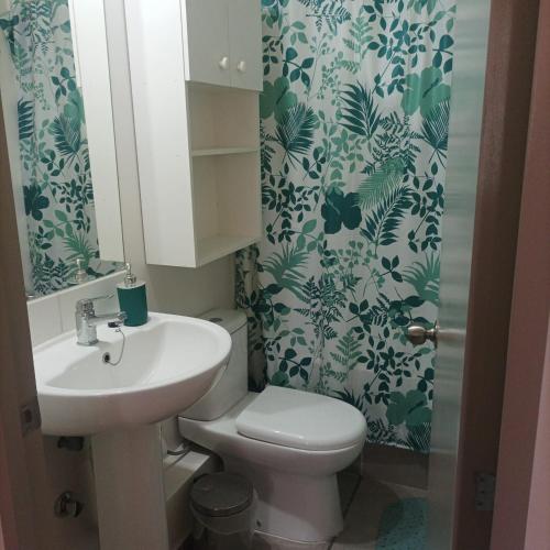 a bathroom with a toilet and a sink at Amplio y comodo departamento in La Serena