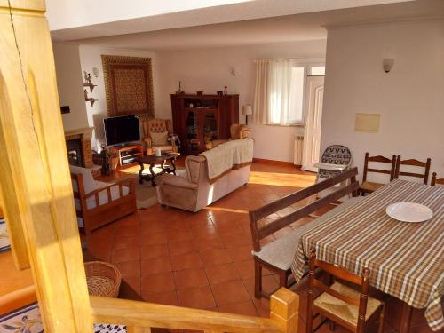 sala de estar con sofá, mesa y sillas en Casa das Oliveiras - Manteigas, en Manteigas
