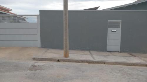 a white garage with a pole in the middle of it at Vaz Lobo Kitnets in Mococa