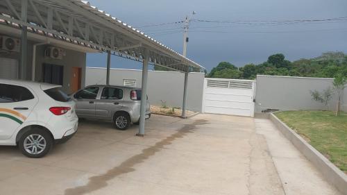 two cars parked in front of a house at Vaz Lobo Kitnets in Mococa