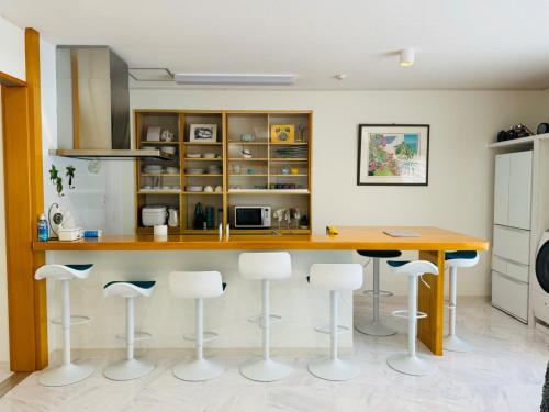 uma cozinha com um balcão de madeira e bancos em Ie shima-MONKEY - Vacation STAY 48431v em Ie