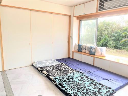 Habitación con colchón en el suelo junto a una ventana en Ie shima-MONKEY - Vacation STAY 48431v, en Ie