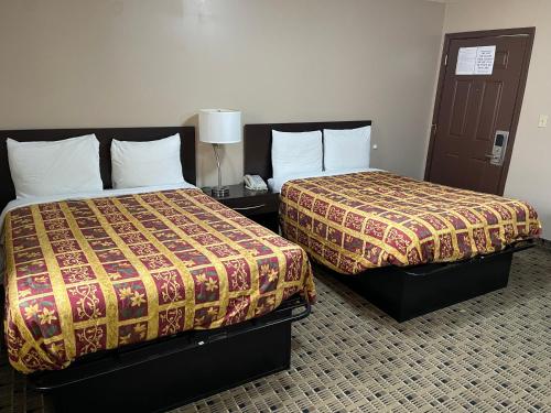 two beds sitting next to each other in a room at Economy Inn & Suites in Ashtabula