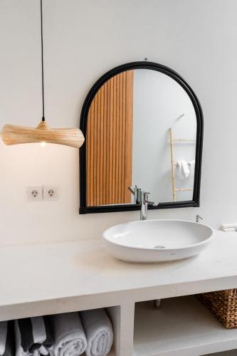 a bathroom with a sink and a mirror at Shanti Boutique Retreat in Tanah Lot