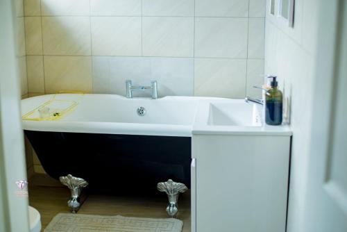 a bathroom with a bath tub and a sink at Crystal Apartments Area 43 in Lilongwe