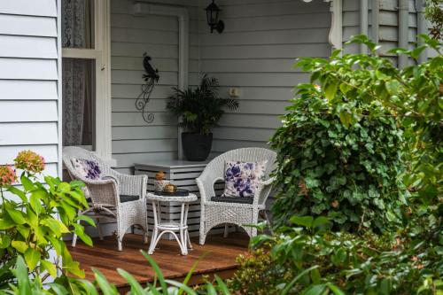 a patio with wicker chairs and a table on a porch at Heytesbury House in Cobden