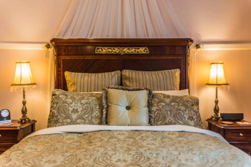a bedroom with a large bed with two lamps at Heytesbury House in Cobden