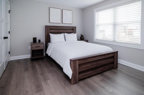 a white bedroom with a large bed and a window at Rest in Westerly in Westerly