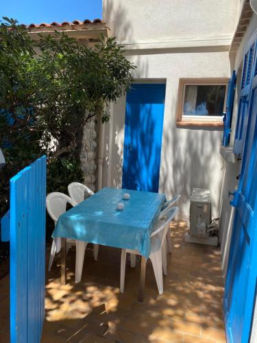 une table et des chaises bleues sur une terrasse dans l'établissement Hyères studio les pieds dans l eau Au Grand Sud, à Hyères