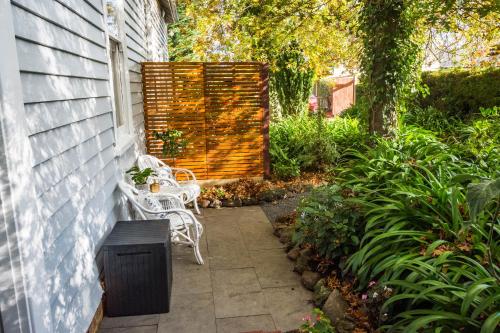 a patio with two white chairs and a fence at Heytesbury House in Cobden