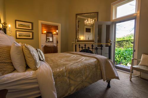 a bedroom with a bed and a mirror and a window at Heytesbury House in Cobden