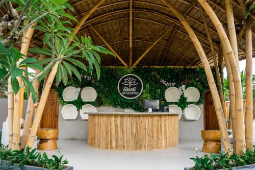 a restaurant with a counter in a resort with palm trees at Shanti Boutique Retreat in Tanah Lot