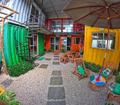 帕拉蒂的住宿－Container Hospedaria Paraty，庭院配有桌椅和遮阳伞。
