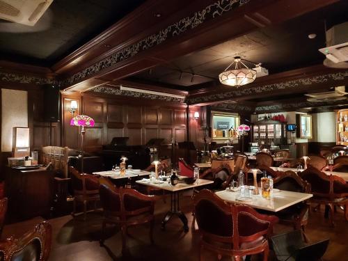 a restaurant with tables and chairs and a chandelier at Coex Stay in Seoul