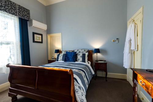 a bedroom with a bed with blue walls and a window at Heytesbury House in Cobden