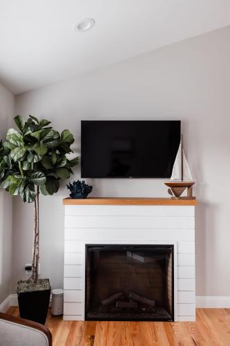 a living room with a fireplace with a tv above it at Rest in Westerly in Westerly