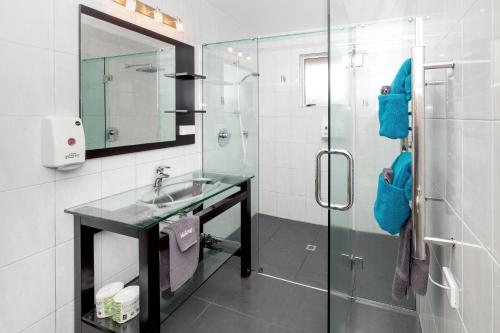 a bathroom with a sink and a glass shower at Ohakune TOP 10 Holiday Park in Ohakune