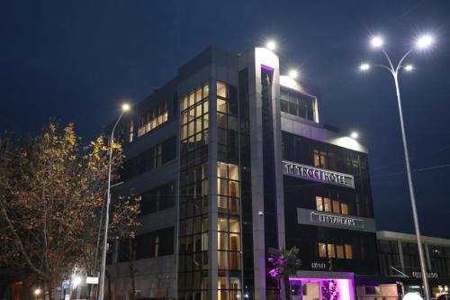 ein hohes Gebäude mit Lichtern in der Nacht in der Unterkunft Troci Hotel in Tirana