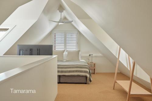 a attic bedroom with a bed and a ceiling at Bluewater on the Beach in Byron Bay