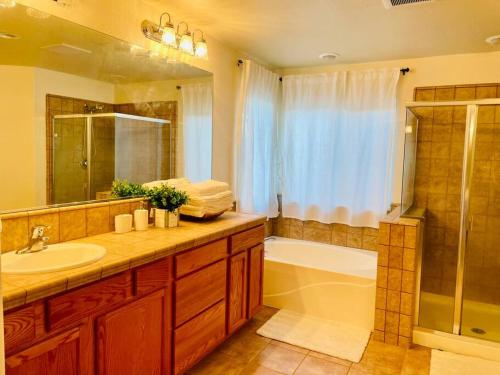 ein Badezimmer mit einem Waschbecken, einer Dusche und einer Badewanne in der Unterkunft New remodel farmhouse style w/ 4bedrooms +3 baths in Elk Grove