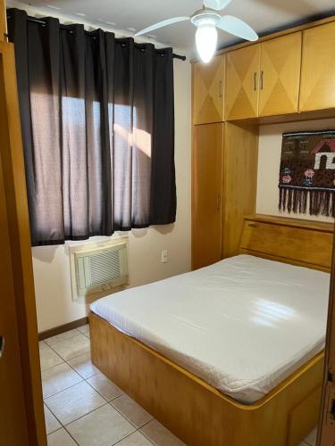 a small bedroom with a bed and a window at apartamento na praia de Porto belo - SC in Porto Belo