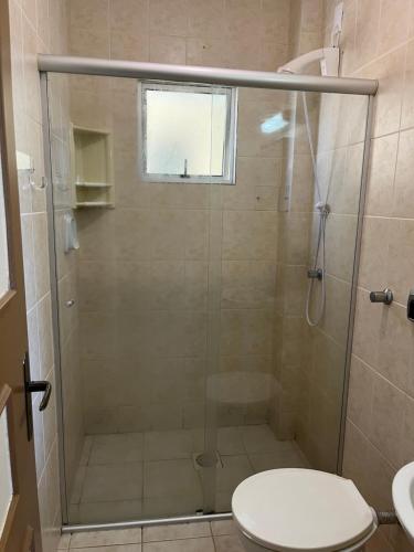 a bathroom with a shower with a toilet and a window at apartamento na praia de Porto belo - SC in Porto Belo
