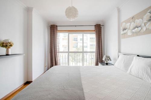 Apartamento em Lisboa, perto de Sintra في Fontainhas: غرفة نوم بسرير كبير مع نافذة كبيرة