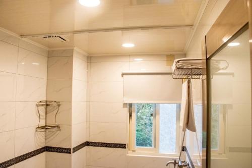 a bathroom with a shower and a window at Boss's home in Dongshan