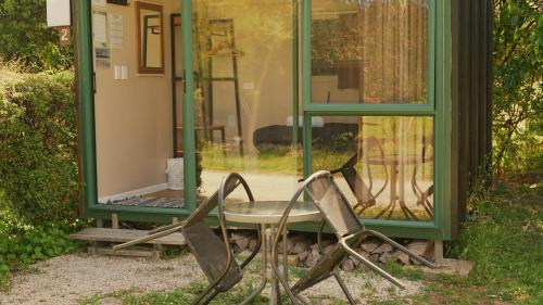 a chair and a table in front of a mirror at The Barn Cabins & Camp in Marahau