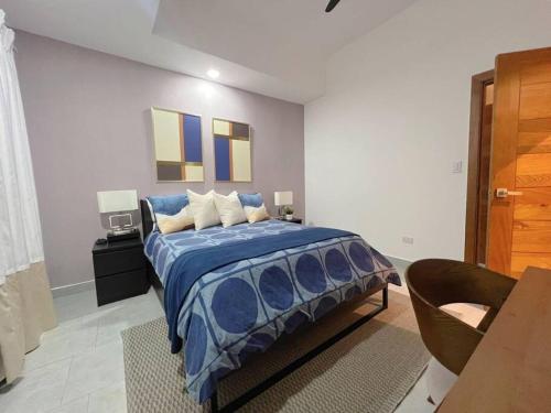a bedroom with a bed with a blue comforter at Refa 304 in Santo Domingo