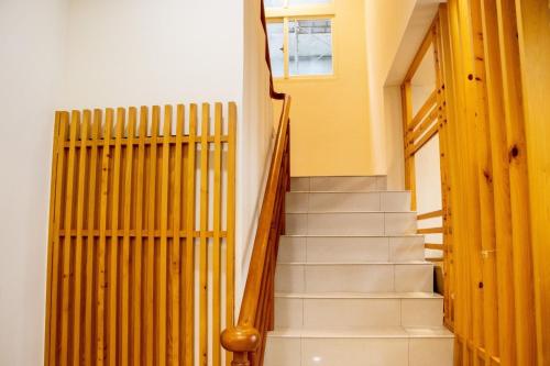 a staircase in a building with yellow walls and wooden railings at Boss's home in Dongshan