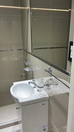 Baño blanco con lavabo y espejo en Soldemonte en Monte Hermoso