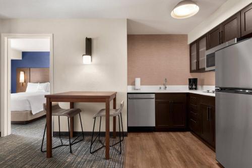 a kitchen with a table and a kitchen with a bed at Residence Inn by Marriott Salinas Monterey in Salinas