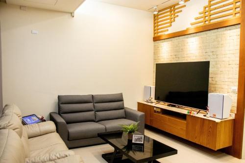 a living room with a couch and a flat screen tv at Boss's home in Dongshan
