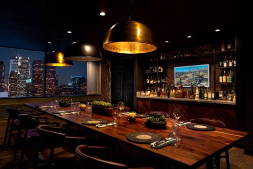 a bar with a long wooden table and chairs at The Ritz-Carlton, Los Angeles L.A. Live in Los Angeles